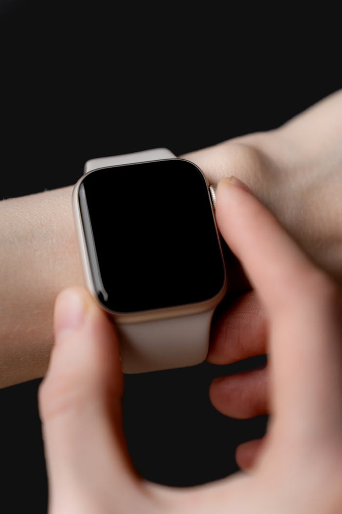 A hand interacts with a sleek smartwatch, showcasing modern technology in a minimalist style.